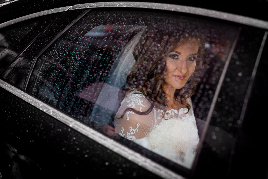 Ślub w deszczowy dzień - fotograf ślubny Wrocław - portret Panny Młodej przez szybę samochodu
